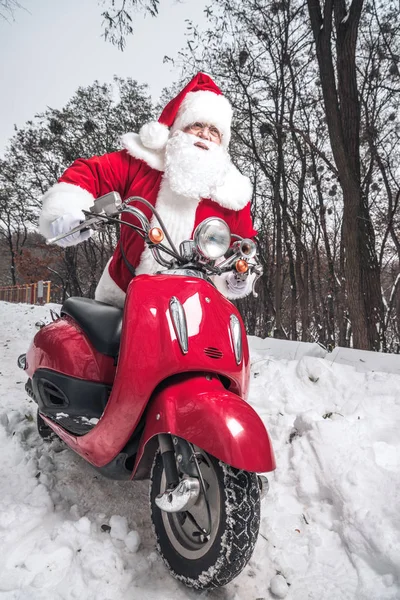 Санта Клаус сидит на красном скутере — стоковое фото