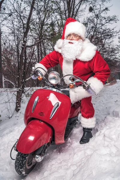 Santa Claus équitation scooter rouge — Photo de stock