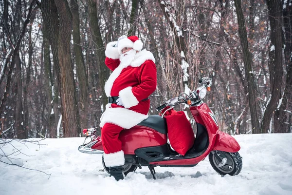 Papai Noel sentado em scooter vermelho — Fotografia de Stock