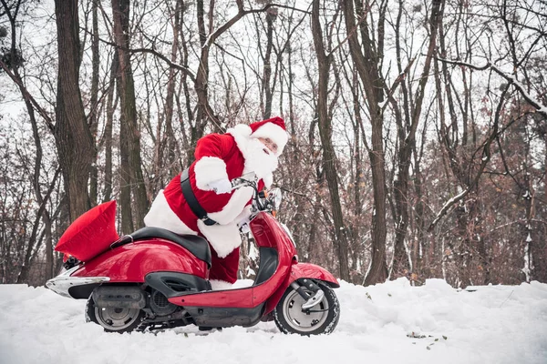 Papai Noel montando scooter vermelho — Fotografia de Stock