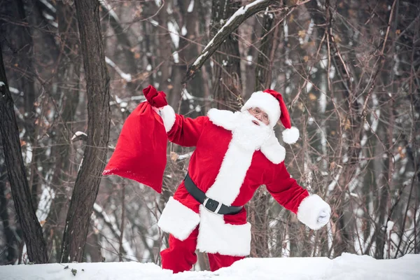 Papai Noel andando com saco cheio de presentes — Fotografia de Stock