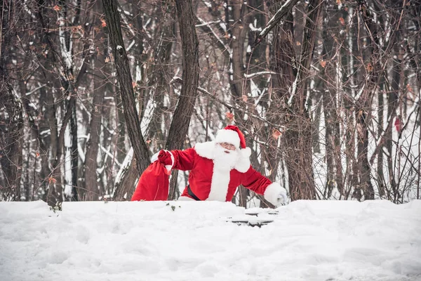 Santa Claus caminando con el saco lleno de regalos - foto de stock