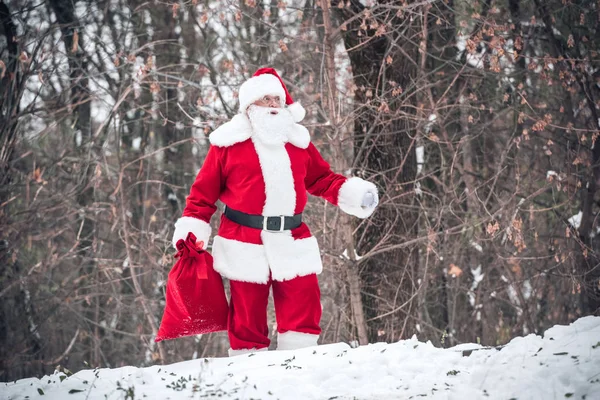 Père Noël marche avec un sac plein de cadeaux — Photo de stock