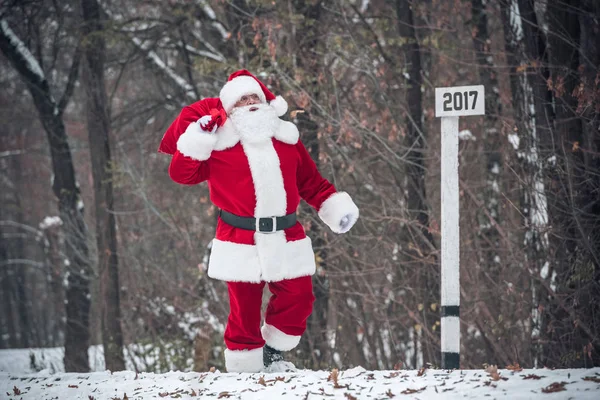 Papai Noel andando com saco nas costas — Fotografia de Stock