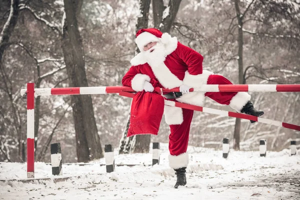 Papai Noel escalando barreira — Fotografia de Stock
