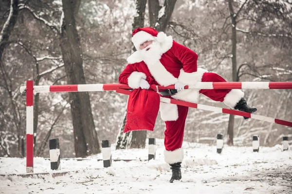 Père Noël grimpant sur la barrière — Photo de stock