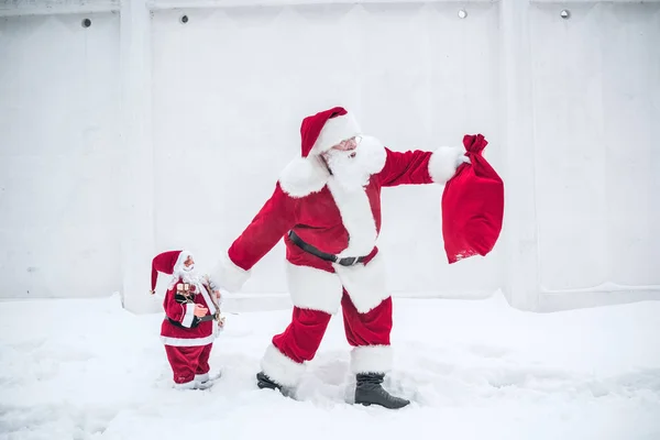 Weihnachtsmann geht mit kleinem Weihnachtsmann — Stockfoto