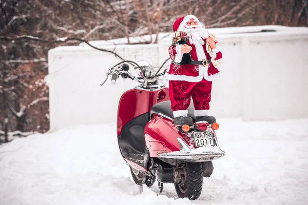 Weihnachtsmann steht auf dem Rücken eines Motorrollers — Stockfoto