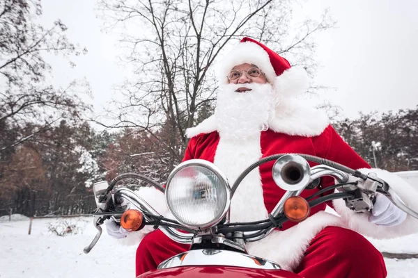 Santa Claus équitation scooter rouge — Photo de stock