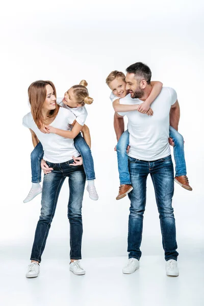 Genitori piggybacking bambini felici — Foto stock