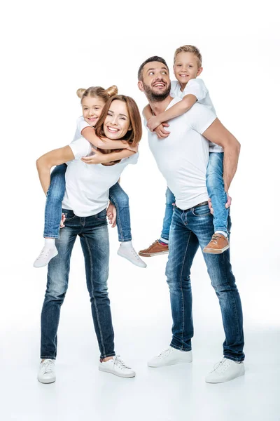 Genitori piggybacking bambini felici — Foto stock