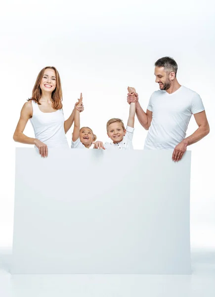 Família sorridente segurando cartão em branco — Fotografia de Stock