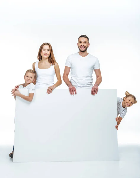 Familia feliz sosteniendo tarjeta en blanco - foto de stock