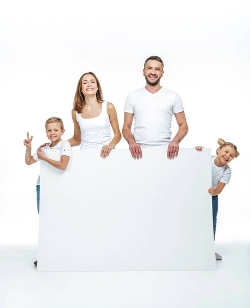 Familia feliz sosteniendo tarjeta en blanco - foto de stock