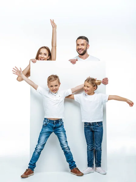 Família alegre segurando cartão em branco — Fotografia de Stock