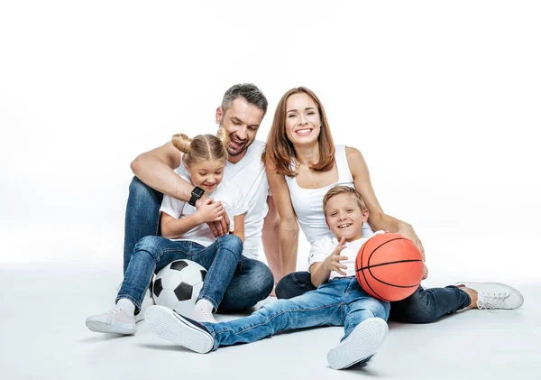 Famille joyeuse avec des ballons de football et de basket — Photo de stock