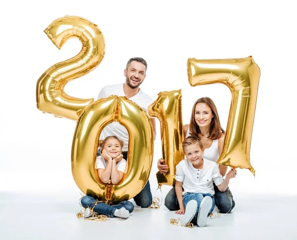 Familia feliz sosteniendo globos dorados - foto de stock