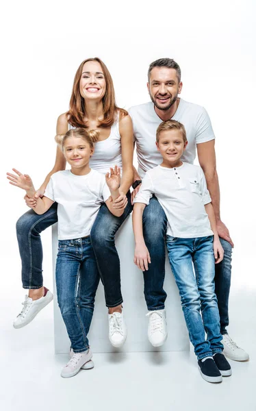 Счастливые родители с детьми в белых футболках — стоковое фото