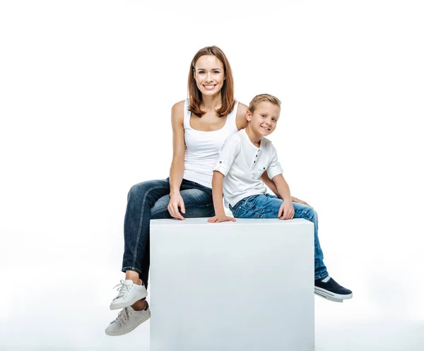 Sonriente madre con hijo sentado juntos - foto de stock