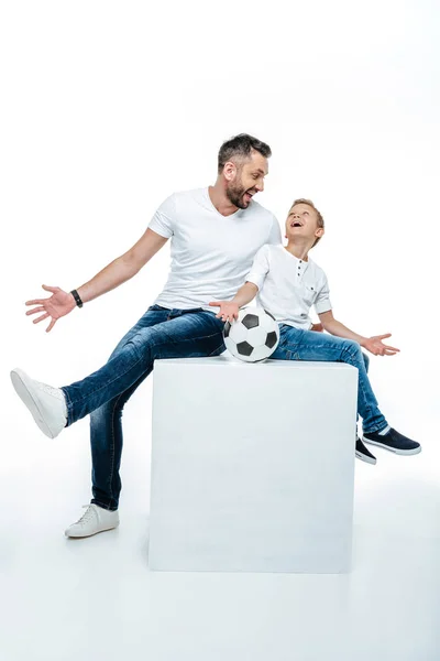 Padre e hijo sentado con pelota de fútbol - foto de stock