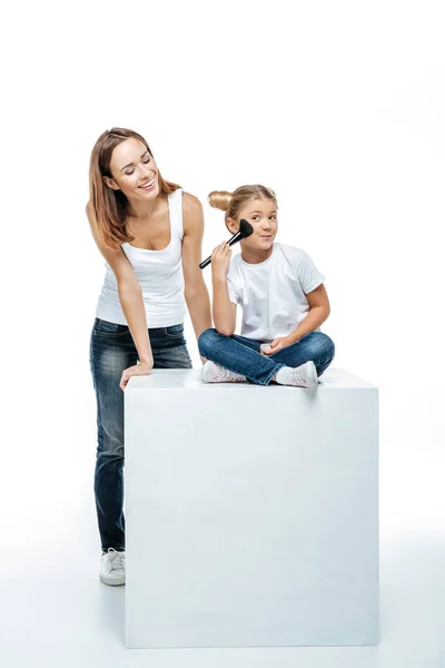 Mãe olhando para a filha com pincel de maquiagem — Fotografia de Stock