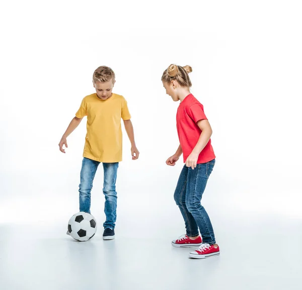 Frères et sœurs jouant avec le ballon de football — Photo de stock