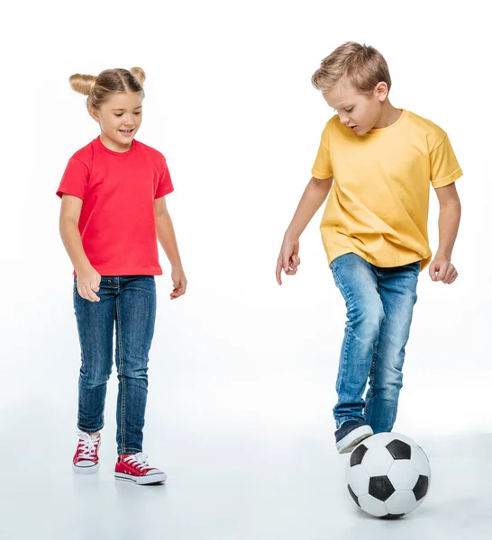 Frères et sœurs jouant avec le ballon de football — Photo de stock