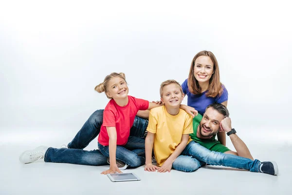 Famiglia sdraiata insieme con tablet digitale — Foto stock