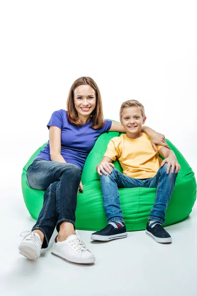 Mãe sorridente com filho sentado em cadeira de saco — Fotografia de Stock