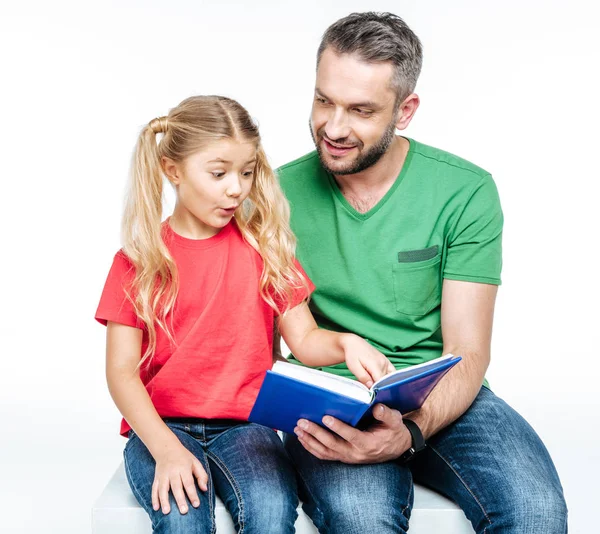 Father and daughter sitting and reading book — Stock Photo