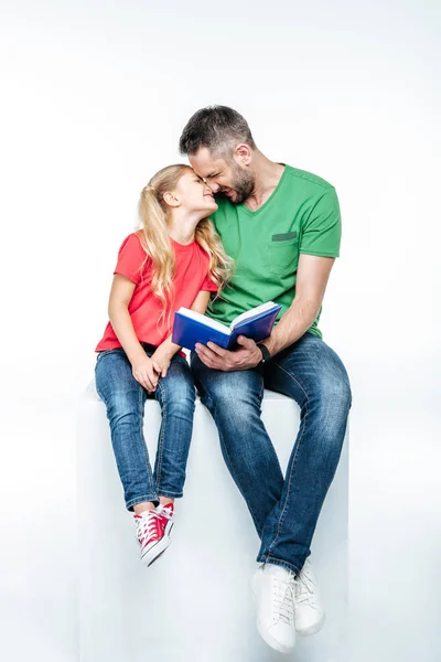 Father and daughter sitting with book — Stock Photo