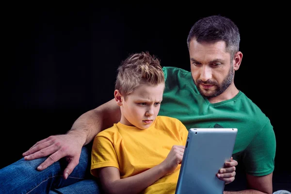 Батько і син використовують цифровий планшет — стокове фото