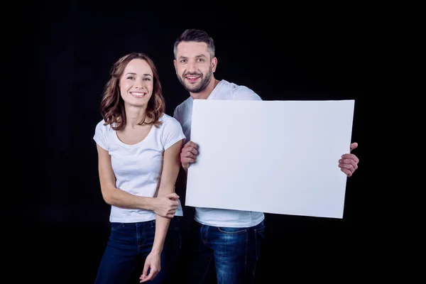 Lächelndes Paar mit Blankokarte — Stockfoto