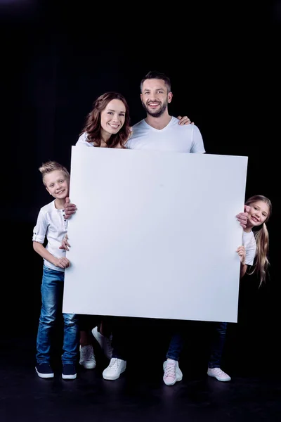 Smiling family holding blank card — Stock Photo