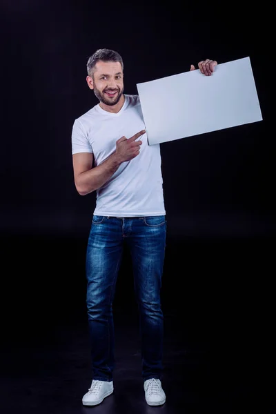 Hombre sonriente sosteniendo la tarjeta en blanco - foto de stock