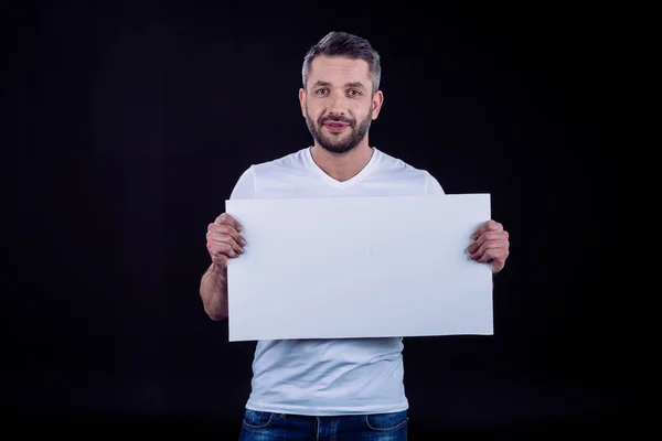 Hombre sonriente sosteniendo la tarjeta en blanco - foto de stock