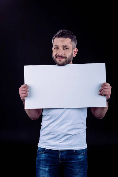 Hombre sonriente sosteniendo la tarjeta en blanco - foto de stock