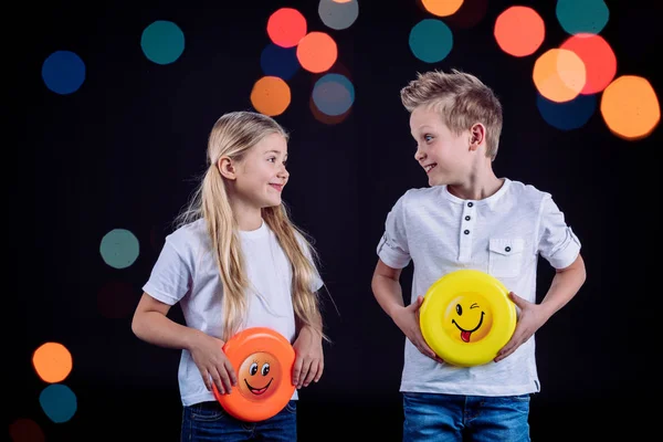 Sonrientes hermanos sosteniendo frisbee — Stock Photo