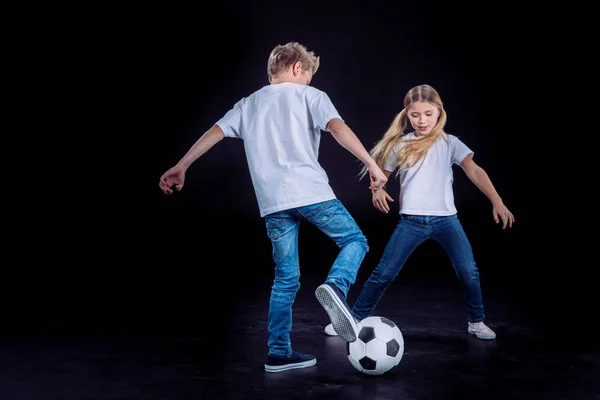 Frère et soeur jouer avec le ballon de football — Photo de stock