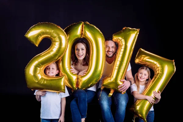 Glückliche Familie mit goldenen Luftballons — Stockfoto