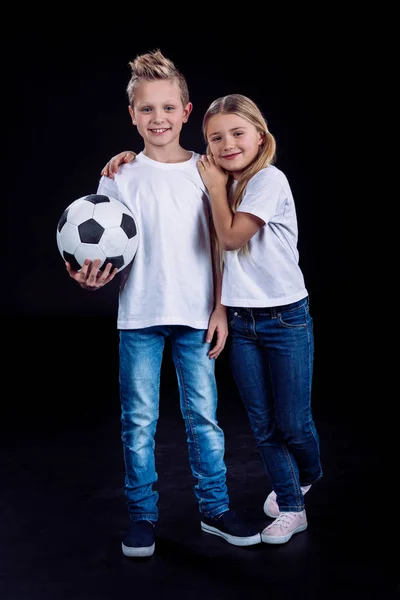 Irmão e irmã posando com bola de futebol — Fotografia de Stock
