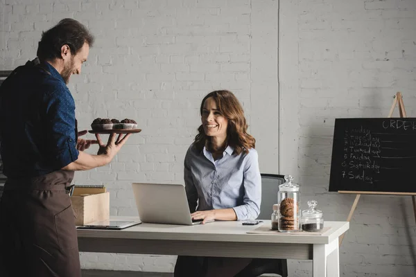 Man showing pastries to young woman — Stock Photo