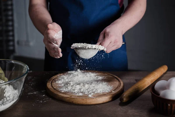 Baker peneirando farinha — Fotografia de Stock