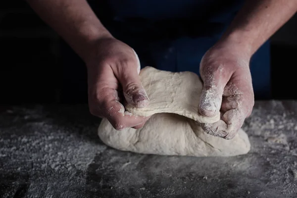 Baker examining dough — Stock Photo