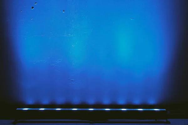 Blaulicht von der Lampe an der Wand als Hintergrund. blauer Lichtstrahl Stockbild