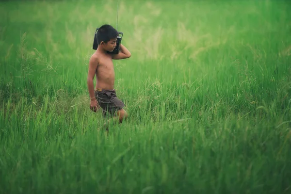 Asian child farmer listening to music — Stock Photo, Image