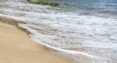 Sandy Beach üzerinde mavi okyanusun dalga yumuşak. Arka plan. Seçici fo