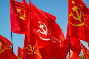 Izyum, Ukrayna - 1 Mayıs 2012 Ukrayna mavi gökyüzüne karşı birkaç bayrakları komünist parti. Ukrayna komünist parti bayrağı. Şimdi Ukrayna Komünist Partisi etkinliğini resmen Ukrayna'da yasaklanmıştır.