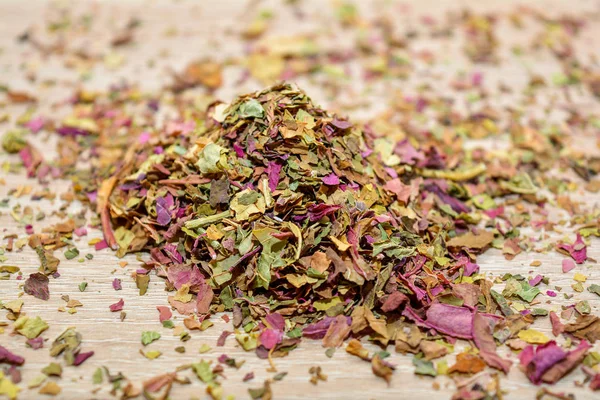 leaves amaranth tea, scattered on the wooden table.