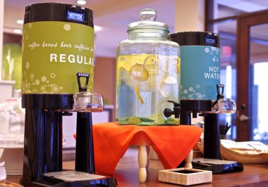 Ferahlık dağıtıcılar kahve, sıcak su ve limon suyu renkli dağıtıcılar görüntülenen bir lobi masanın üzerine yerleştirilen